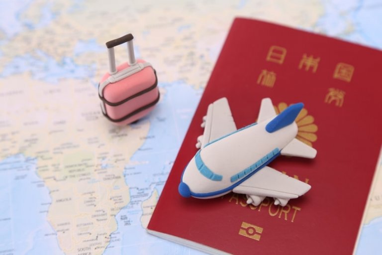 パスポートと飛行機、旅行かばんのイメージ